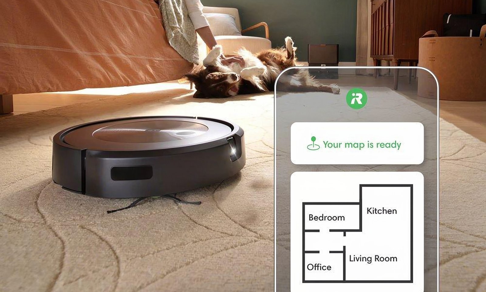 صورة ⁢توضيحية لجهاز iRobot ⁣Roomba j9+. يقوم⁤ الجهاز بتنظيف سجادة ‌بينما يحصل‌ كلب على ⁢تدليك للبطن في الخلفية. تم وضع خريطة منزلية من تطبيق Roomba فوق​ الصورة.